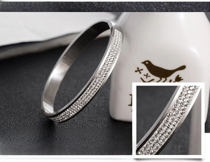 Detail shot of multi-row crystal zircon inlay on a silver stainless steel open bangle