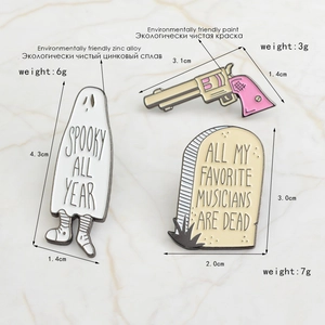 Detail view of enamel pins featuring spooky ghost and pink revolver on marble