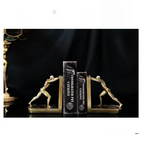 Detailed close-up of golden resin bookends featuring muscular figures in a matte finish