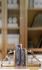 Detail of creative bronze athlete bookends showing artistic sculpture on wooden shelf