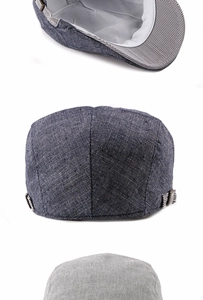 Detail of adjustable metal buckle and striped ribbon on linen flat cap side