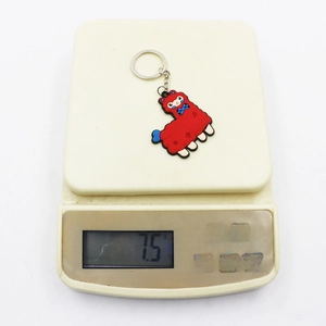 Red PVC llama keychain with blue bowknot and silver metal ring on weighing scale
