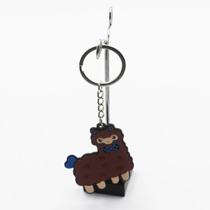 Detail of cute brown alpaca keychain with blue bow tie on a metal silver keyring