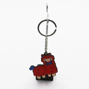 Detailed view of a red cartoon alpaca keychain with blue bow and silver metal keyring