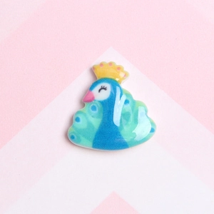 Detailed view of a colorful resin peacock charm for DIY phone cases and accessories