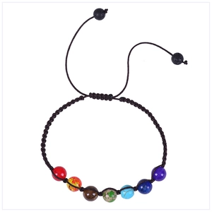 Detailed view of handmade seven chakra braided bracelet with volcanic stone and color beads