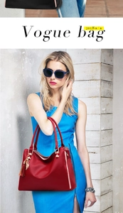 Détail du grand sac cabas en cuir rouge avec pendentif chat doré et pompon sur un mannequin