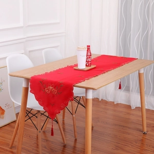 Red Christmas table runner with festive bell embroidery and elegant red tassels