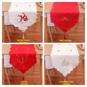 Detail of Christmas table runners with Santa and bell embroidery and elegant tassels