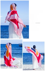 Detail showing multi-color patchwork patterns and tassel edges on the long cotton scarf