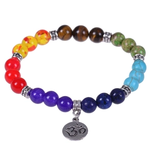 Macro shot of 7 chakra natural stone beads with vintage silver Om symbol charm and spacers