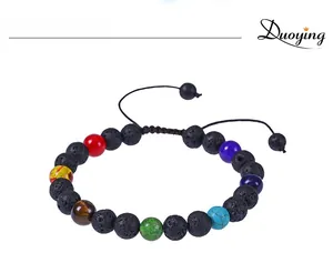 Détail de perles chakra en pierre de lave sur bracelet noir tressé ajustable