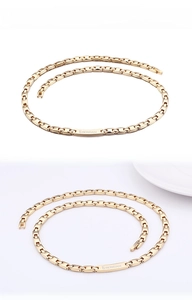 Detail of gold polished link chain with engraved branding on rectangular clasp element