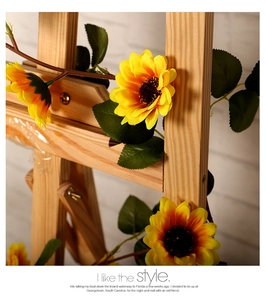 Detailed close-up of artificial sunflower vine with yellow petals on a wooden stand