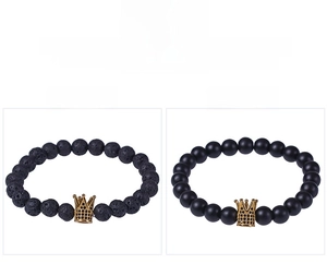 Detail of lava and matte stone bracelets with gold crown charms and micro-pave zircons