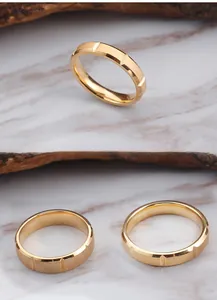 Macro detail of gold plated stainless steel rings with brushed matte finish and geometric grooves