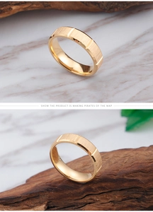 Detailed view of golden brushed stainless steel rings with polished edges on marble