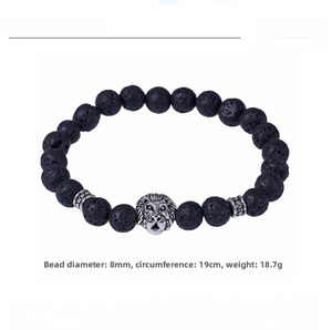 Macro detail of 8mm black lava stone beads and silver lion head charm on the bracelet
