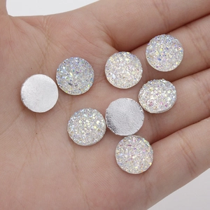 Macro shot of 12mm iridescent white star resin gems held in hand for DIY jewelry making