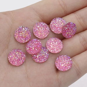 Macro shot of 12mm pink resin starburst rhinestones held in palm for DIY crafts