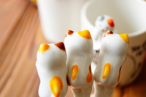 Macro detail of hand-painted ceramic cat stirring spoons with smooth glazed finish