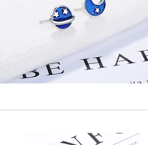 Detailed view of silver star and blue planet studs with sparkling glitter inlay