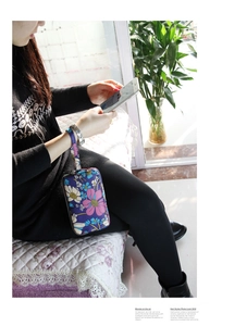 Detail view of floral fabric long clutch with wristlet and three-layer zipper closure