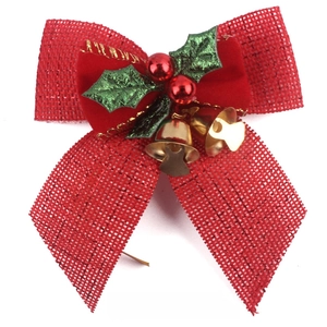 Detail of red linen Christmas bow with velvet layers, holly leaves and gold bells