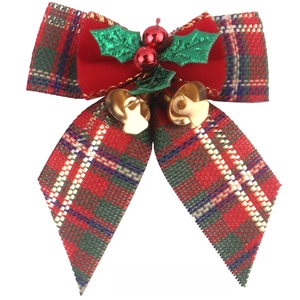 Close-up of Christmas plaid bow with gold bells and festive red berries ornament