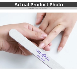 Action shot of grey 100/180 grit double-sided half-moon nail file shaping nails