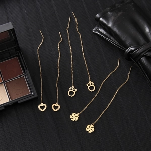 Three pairs of gold drop earrings featuring heart, owl, and flower charms on long chains