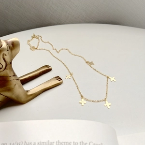 Detail of S925 sterling silver stamp on the back of a gold mini cross necklace