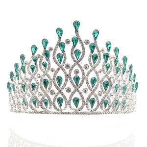 Macro detail of silver bridal crown with luxury green teardrop gems and white rhinestones