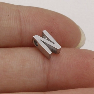 Close-up of 10mm polished stainless steel letter N bead for custom jewelry DIY