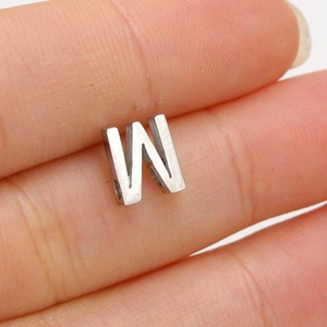 Macro shot of a 10mm stainless steel letter W bead showing size and mirror finish