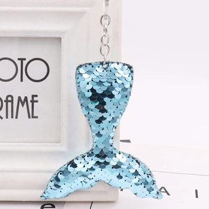 Detailed close-up of a mermaid tail keychain featuring reflective blue sequins and a metal ring