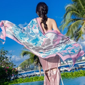 Detail of floral print scarf with pink tassels and lightweight fabric for beach sun protection