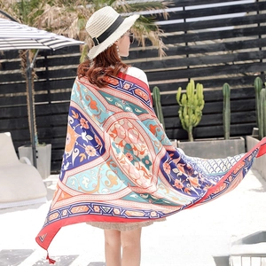 Close-up of bohemian style scarf with colorful ethnic patterns and red fringe tassels