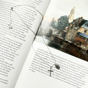 Detail of retro 925 sterling silver cross and oval religious medal on a vintage book