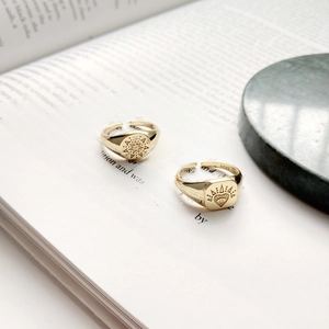 Detailed close-up of 925 sterling silver sun and eye rings on an open book