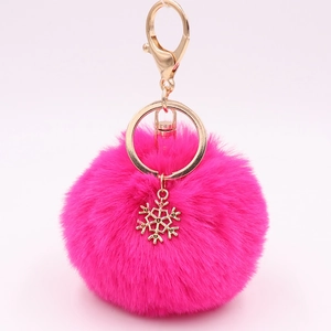 Detail of rose red fluffy pompom keychain with golden snowflake charm and clasp