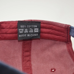 Detail view of cotton baseball cap interior featuring black woven label and 100% cotton logo
