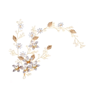 Accessorio per capelli con fiori oro e argento con foglie e perle su sfondo bianco