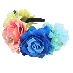 Detailed view of colorful faux roses in pink, blue and yellow on a black velvet headband