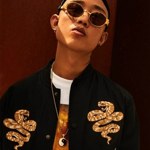 Close-up of Tai Chi Bagua pendant on a gold necklace with street style apparel
