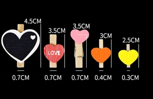 Size comparison of colorful wooden heart clips against a black background showing dimensions
