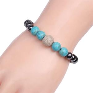 Detail view of elastic bracelet with black magnetic stones and blue turquoise beads on wrist