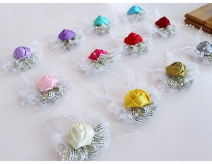 Gros plan de corsages de poignet en roses de satin colorées avec rubans et perles