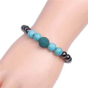 Close-up of magnetic beads and turquoise lava stone bracelet on model's wrist