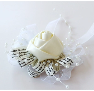 Détail d'un bracelet fleur en satin crème avec dentelle, perles et ruban élégant